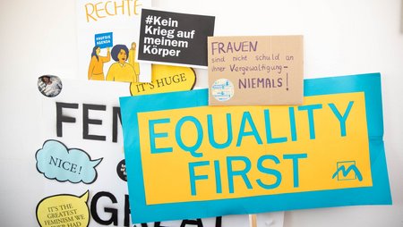 Feminist placards, one with the slogan “Equality first”.