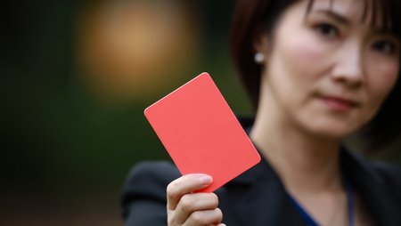 A woman holds a red card into the camera