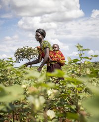 Eine Mutter mit ihrem Kind bei der Feldarbeit in Uganda.